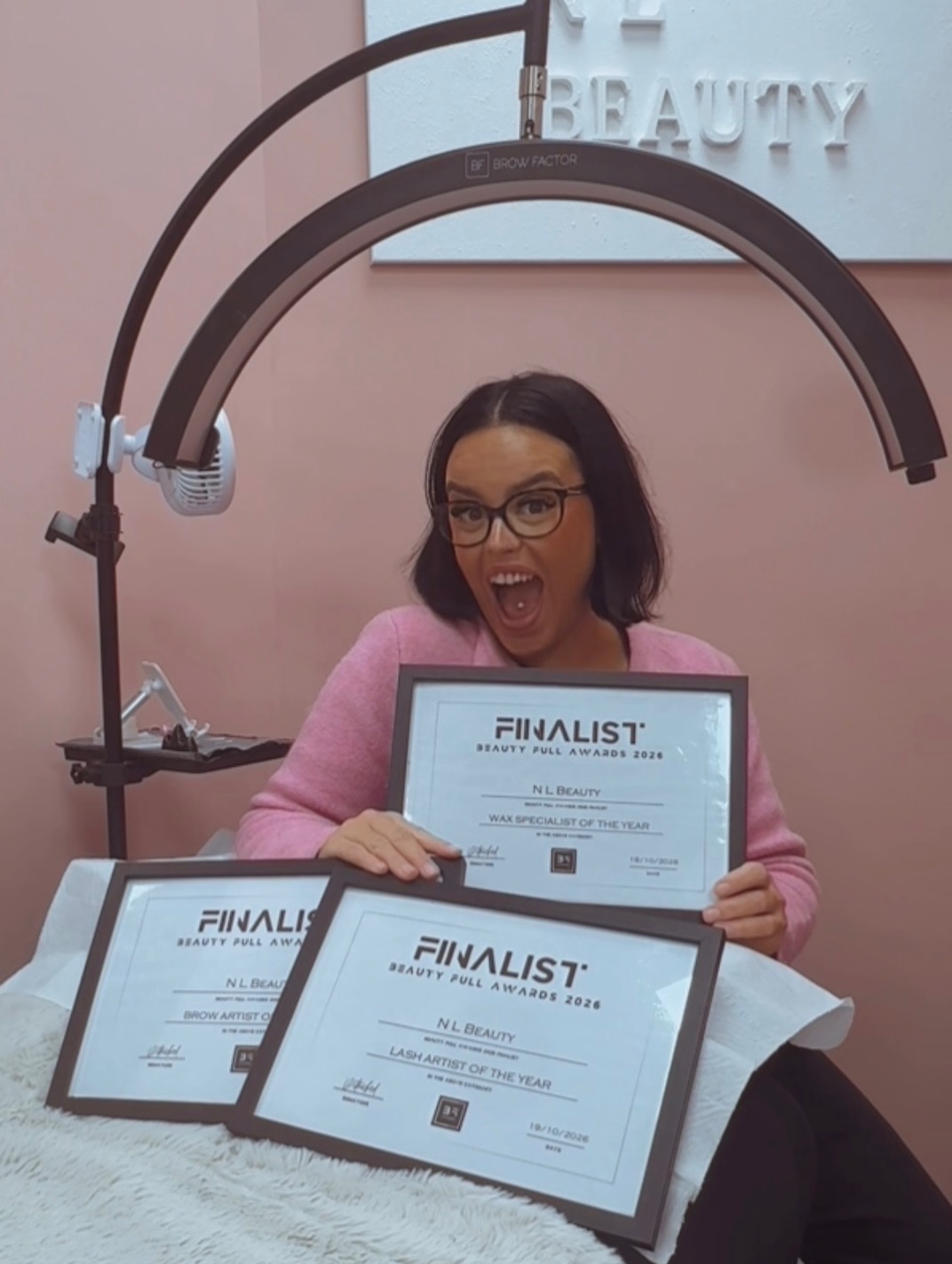Natalie holding her Beauty Full Awards 2026 finalist certificates in the studio