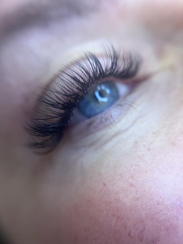 Dark, full lash extensions on a blue eye